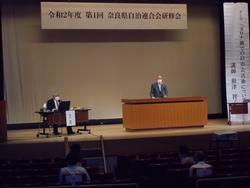 自治連合会研修会開会前に舞台で挨拶する市長