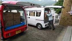 公用車から不織布マスクの入った段ボールを運ぶ市長の写真