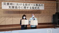 署名された協定書を披露している写真