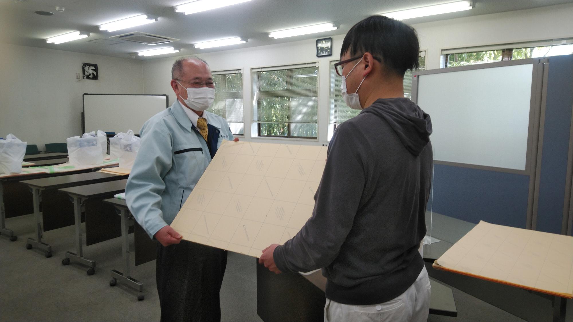アクリルパネルを渡している様子