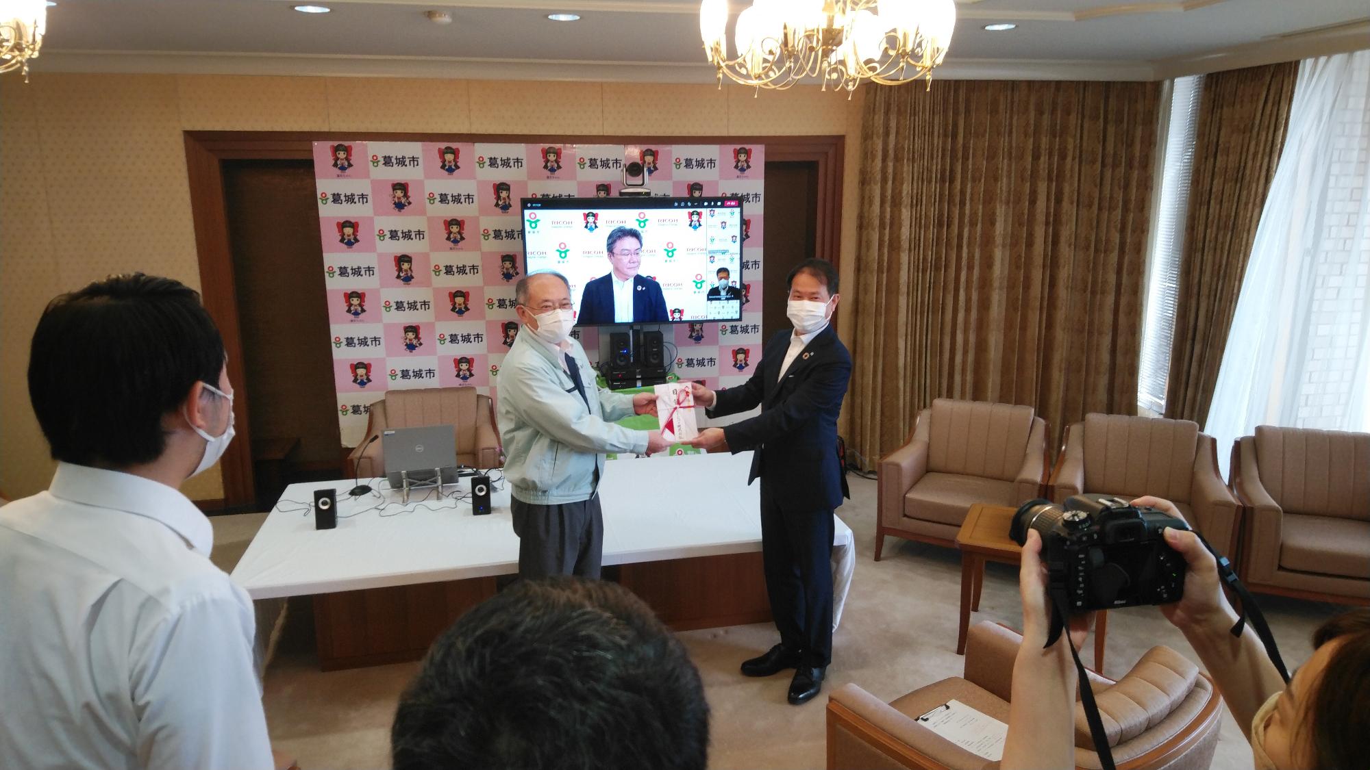 リコージャパン株式会社から目録を贈呈されている様子