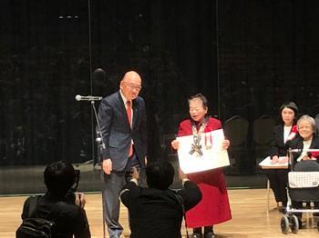 壇上にて表彰を受ける高松久仁子さんの写真