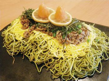 そばの上に具材が盛られ、さらに、のりやレモン、もみじおろし等の薬味が盛りつけられた料理の写真