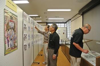 アニメのポスターや設定イラストの描かれたボードが展示パネルで展示されている様子の写真