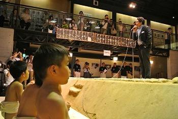 子ども力士をはじめとする人々の前で土俵の上で挨拶される貴乃花親方の写真