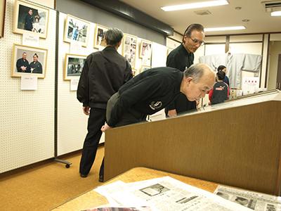 羽織やパネル展示されている写真や机に配置されている資料とそれが観覧されている様子の写真