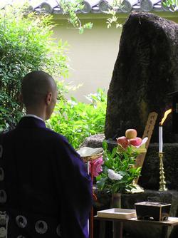 髪塚を前に法会を営む導師の写真