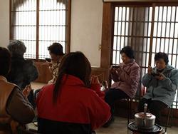 椀と箸を持って椅子に座っている人々の写真