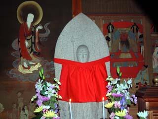 中央に安置された地蔵尊の写真。西面壁画に左・地蔵菩薩、右・閻魔明王の絵図が描かれている