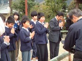手を合わせてお参りする高学年児童たちの写真