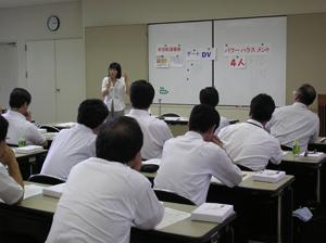 会議室においてホワイトボードにパワーハラスメントなどの単語を張りながら講演を行っている様子の写真