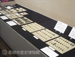 台の上に大小様ざまな石器が規則正しく並べられている展示風景の写真