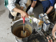 バケツに入った廃食油石けんをスコップで分解している写真