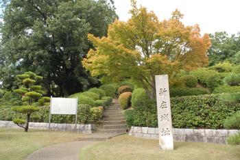 屋敷山公園敷地内にて撮影された新庄城の風景写真。屋敷山古墳のそばに「新庄城」と刻まれた石碑と案内板が確認できる