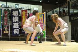相撲館の館内にある土俵の上でまわしを付けて相撲を取ろうとしている女性2人の写真