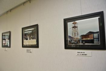 「けはや座」25周年写真展の展示風景の写真。相撲館の歴史に関連した写真が館内壁面に展示されている様子がうかがえる