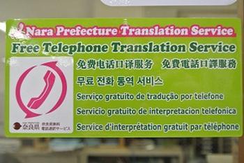 7種の言語で書かれた無料通訳サービスのステッカーの写真