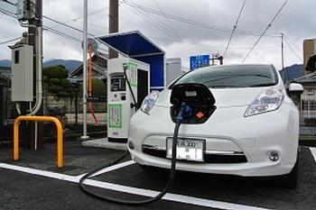 葛城市相撲館にあるEV充電スタンドで充電している白いEV車の写真