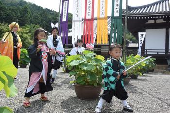 當麻寺奥院にて、「鬼滅の刃」の各キャラクタに扮して撮影に応じるファンの写真。写真奥に奥院本堂と阿弥陀堂が確認できる