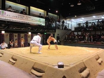 相撲館の土俵で行われている小学生の相撲の写真