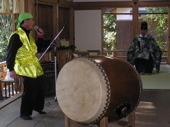 情報番組にエキストラ出演したシンガーソングライターの高松昌弘さんが和太鼓の横で歌っている写真