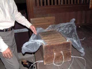 中にビニールに包まれた絵馬一組が収納されているミカン箱ほどの大きさの木箱を開けた時の写真