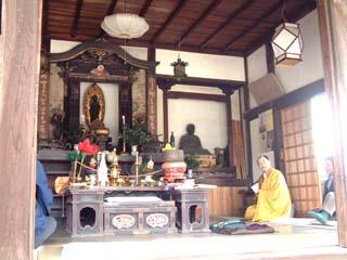 十一面観音と真済像が並ぶ柿本寺本堂で住職による法要が行われている写真
