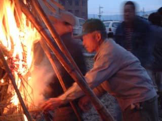 トンドを支えている竹の間に男性が手を入れて火を付けた時の写真