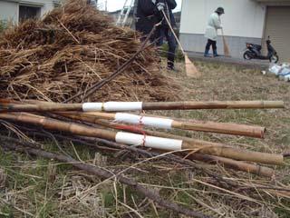刈り終わった田圃に集められた、トンドを作るための材料である藁や竹の杭などの写真