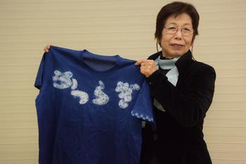青地に白文字で「かつらぎ」と書かれたTシャツを両手に持っている女性の写真