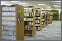 平均6段の、天井近くまで高さがある本棚が並んでいる一般開架室の写真