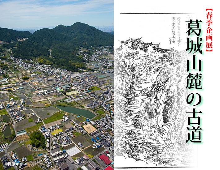 上空から見下ろす山と市街地の写真と山道のイラストが載った、春季企画展「葛城山麓の古道」のポスター