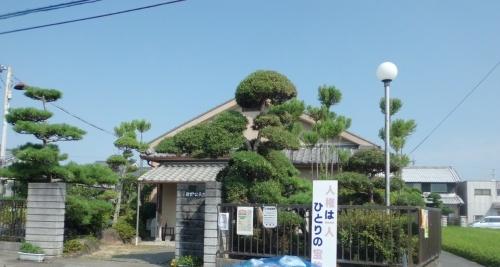 石造りの門の奥に植木に囲まれている公民館染野分館の写真